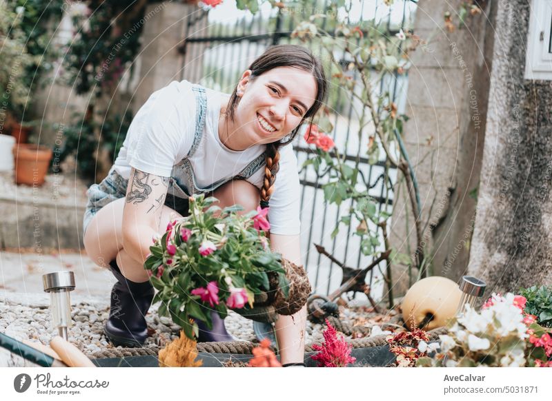 Porträt einer jungen Gärtnerin in ihrem Hausgarten, die sich um die Blumen kümmert, neue Heimaktivitäten. Frau Gartenarbeit Gewächshaus Kaukasier wachsend Job