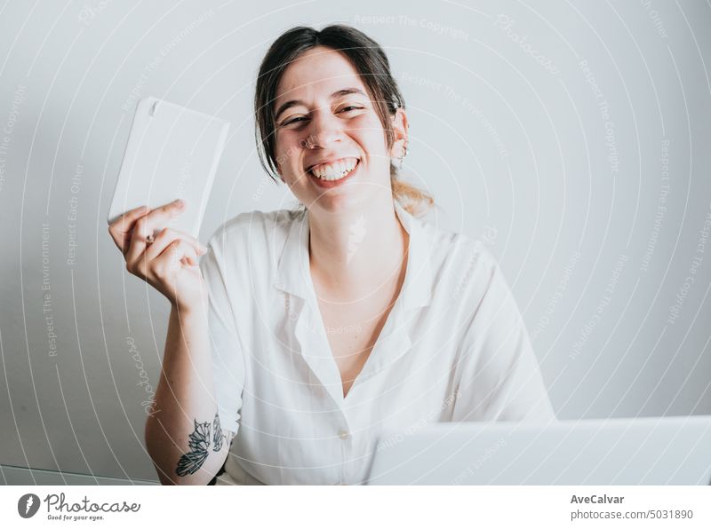 Junge und lächelnde Geschäftsfrau, die mit einem Laptop arbeitet, während sie Notizen macht, Porträtbild Kopierraum Person Büro Business Frau heiter klug