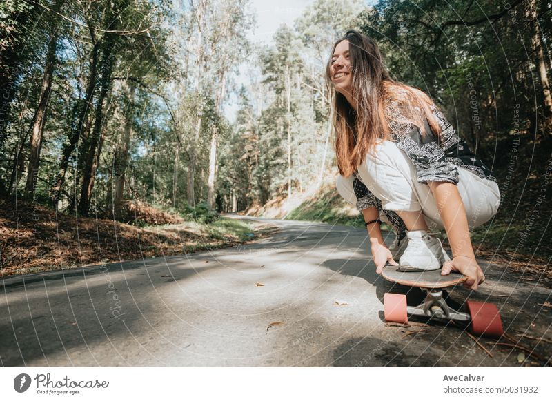 Sportliche Frau fährt auf dem Skateboard auf dem Waldweg. Longboarding, weiblich.Gen Z Sport Aktivität Bewegung Menschen Erwachsener Lifestyle Straße