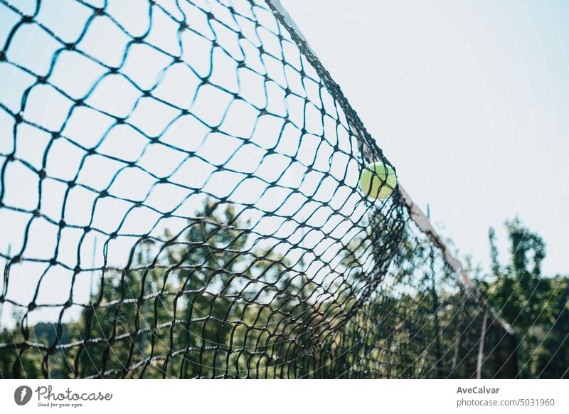 Zeitstoppbild eines Tennisballs, der gegen das Tennisplatznetz mit Kopierraum kracht, Sportkonzept Netz Gericht Spiel Konkurrenz Streichholz spielen Ball