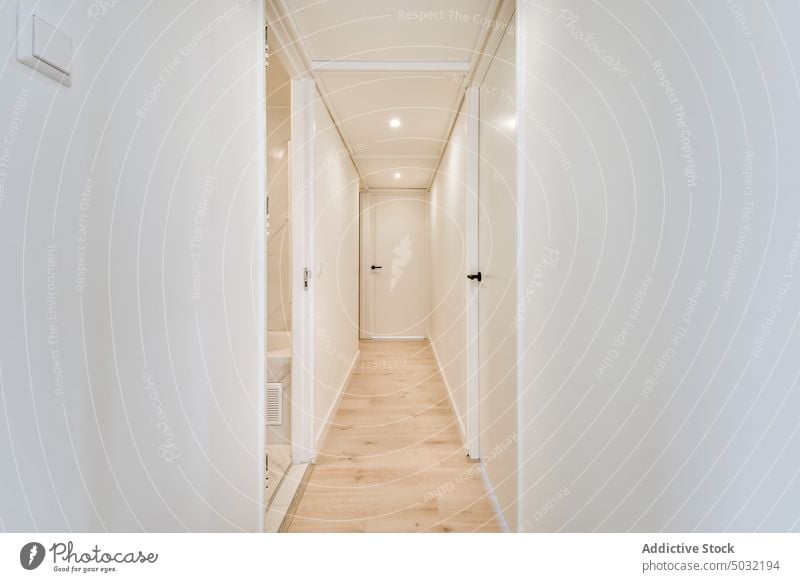 Flur mit weißen Wänden und Laminatboden in der Wohnung Gang Appartement Innenbereich Tür geräumig wohnbedingt Eingang Stil modern Anwesen flach Zeitgenosse