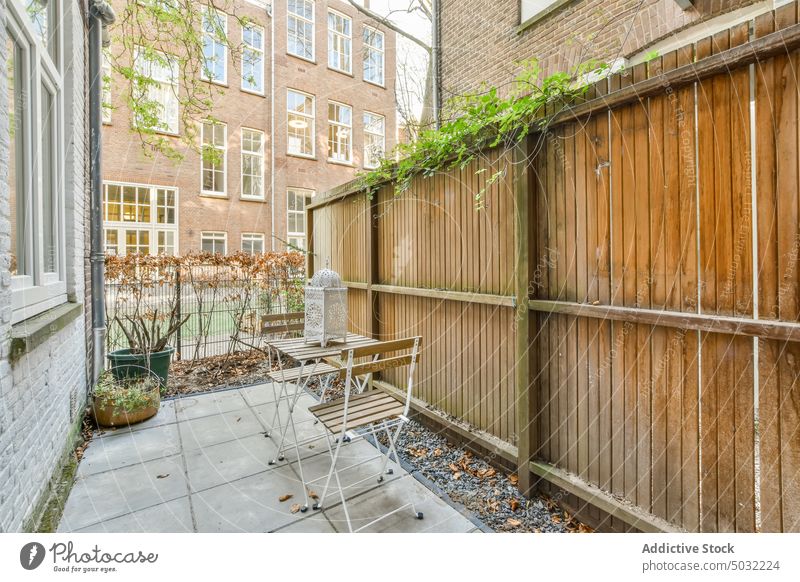 Hinterhof eines Hauses mit Tisch und Stühlen Pflanze Stuhl Baum Gras grün im Freien Außenseite heimwärts Architektur Fenster Garten hölzern keine Menschen