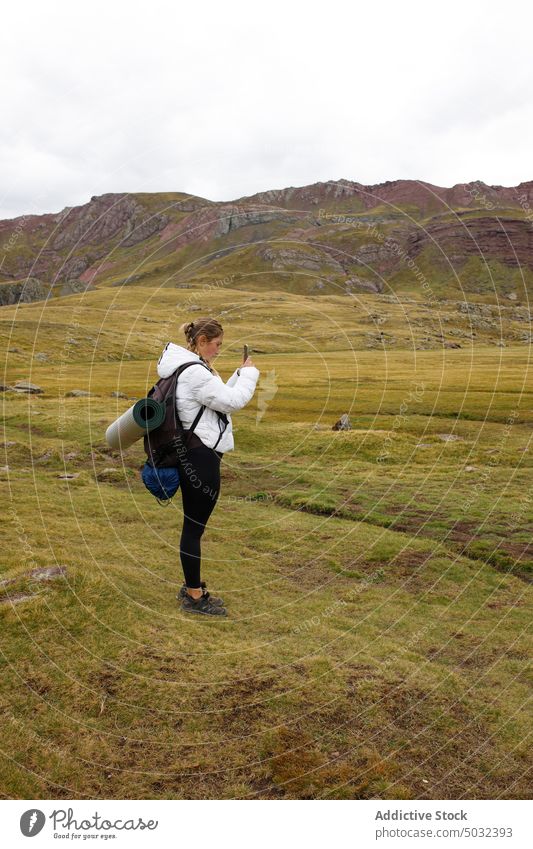 Weibliche Reisende fotografiert die Berge Frau Reisender fotografieren Berge u. Gebirge Wanderung Tal Smartphone Sommer Kamm Natur Wochenende wolkig Himmel