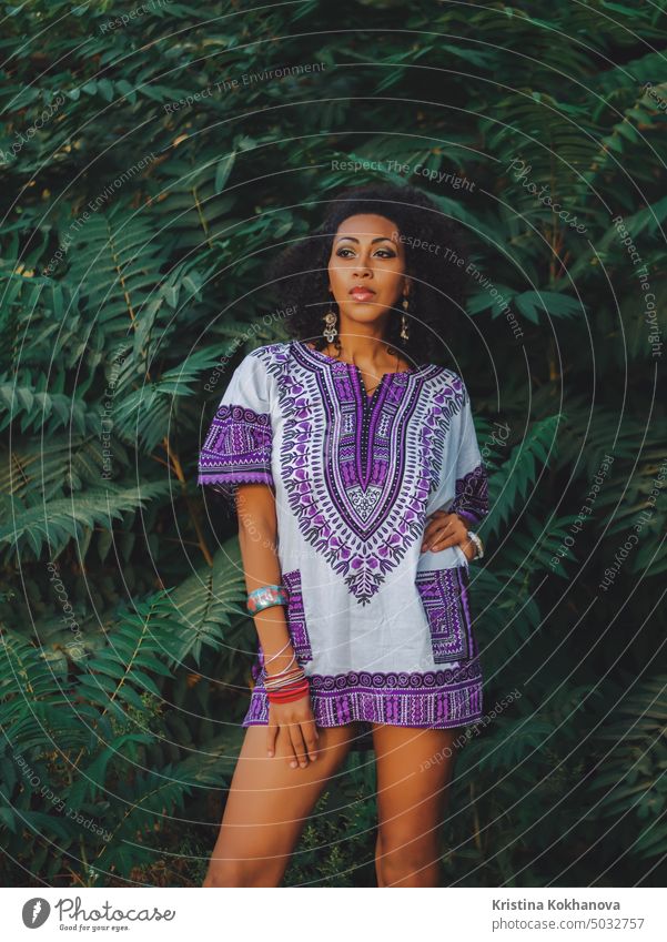 Afro-amerikanische Frau im Freien. Multi ethnischen Mädchen tragen bunte Kleidung posiert, genießt die Natur. Grüner tropischer Hintergrund Afrikanisch