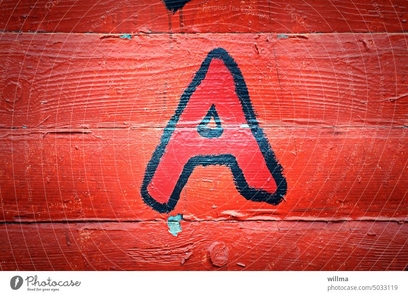 Der Buchstabe A auf roter Bretterwand Schriftzeichen Graffiti aufgemalt Holzwand Anfänger