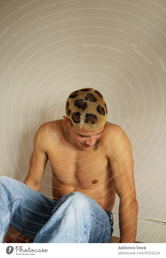 Hemdloser junger Mann mit gefärbtem Haar Lächeln Glück ohne Hemd Vorschein gefärbtes Haar informell Subkultur Porträt heimwärts männlich Leopard Individualität