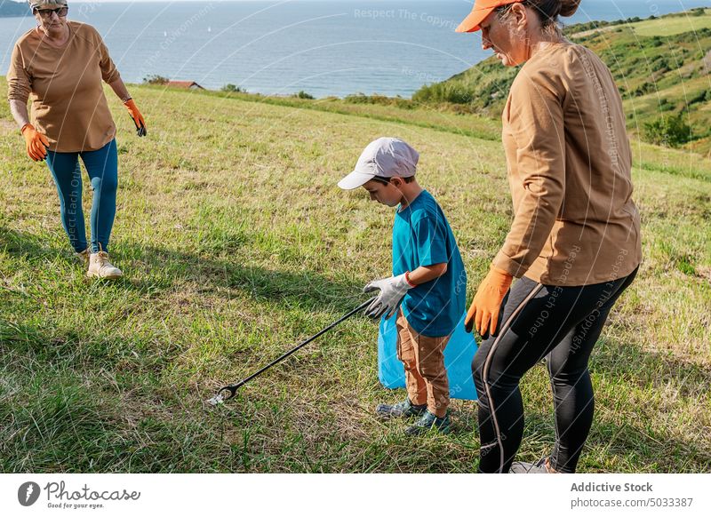 Freiwillige Helfer sammeln Müll auf einer Wiese in der Natur Freiwilliger Umwelt abholen Tasche Frau Junge Großmutter Ökologie Landschaft Abfall verschmutzen