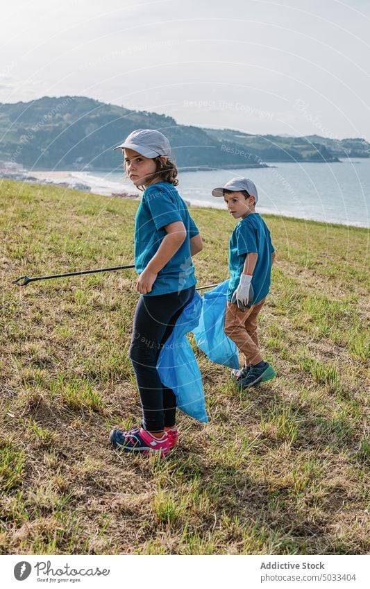 Kinder sammeln Müll am Ufer in der Nähe des Meeres Mädchen Junge Freiwilliger abholen Natur umweltfreundlich Umwelt MEER Tasche Öko Hügel wiederverwerten