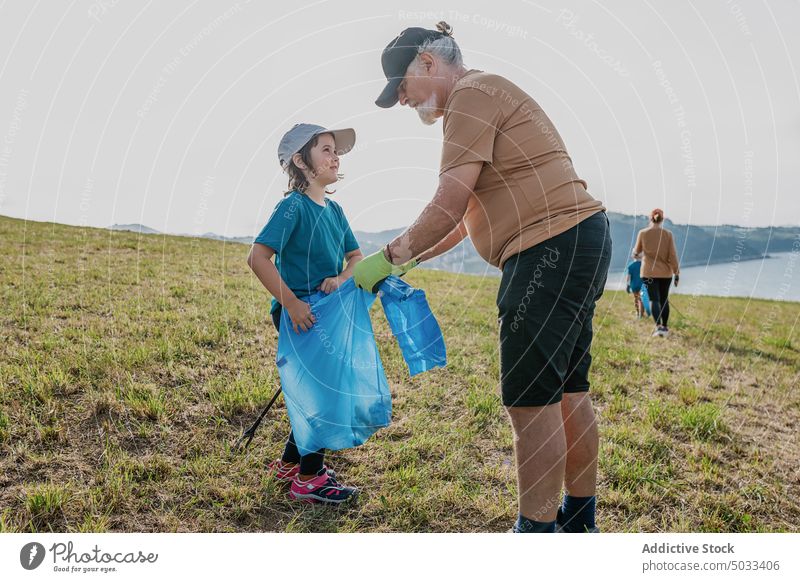 Eine Gruppe von Freiwilligen sammelt Müll am Ufer des Meeres Menschen Mädchen Großvater Mutter Junge Menschengruppe Freiwilliger abholen Natur umweltfreundlich