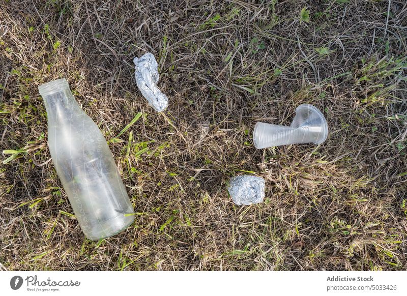 Plastikmüll auf der Wiese Müll Abfall Kunststoff Flasche Tasse Folie verschmutzen verwendet Gras Umwelt Container Ökologie Natur Einwegartikel Feld Rasen