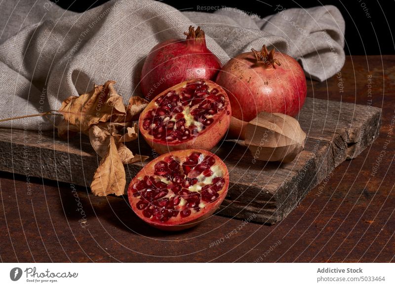 Reifer Granatapfel auf Holzbrett reif Frucht dunkel Samen Ordnung frisch hölzern Holzplatte Gesundheit Lebensmittel Feinschmecker Mahlzeit natürlich organisch