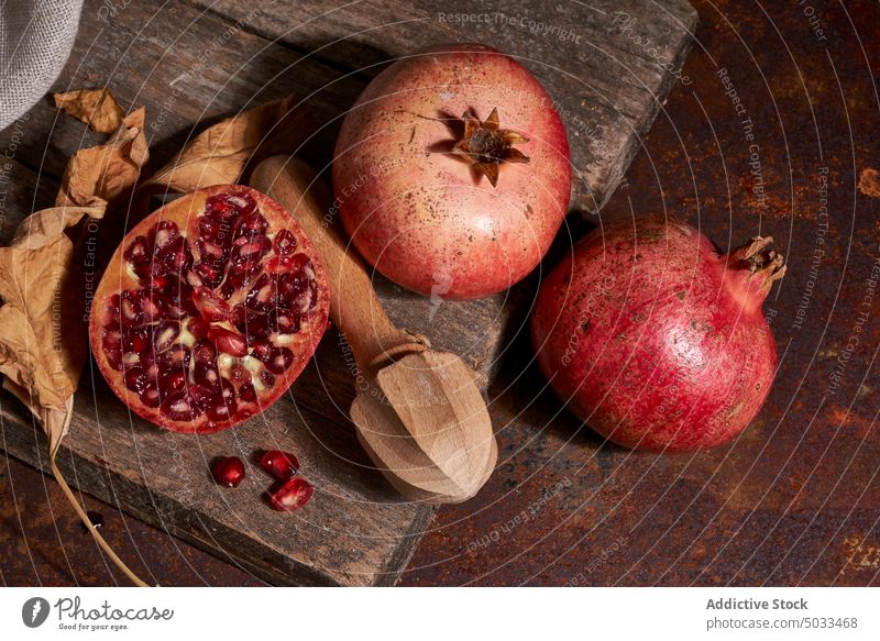 Reifer Granatapfel auf Holzbrett reif Frucht dunkel Samen Ordnung frisch hölzern Holzplatte Gesundheit Lebensmittel Feinschmecker Mahlzeit natürlich organisch