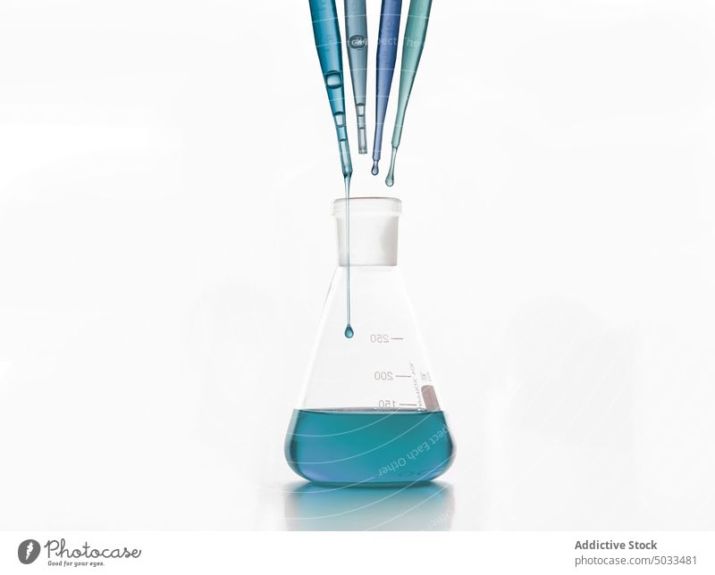 Tropfen über einem Laborkolben, der auf einer weißen Fläche steht Flasche Tropfer Experiment Glaswaren Pipette forschen Probe Biochemie Chemie liquide Prüfung