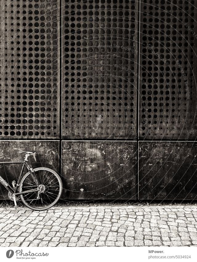 rostiges rad anrostiger hauswand fahrrad alt weg Pflastersteine Fasade gelocht Rost Metall Fahrrad Verkehrsmittel Fahrradfahren Außenaufnahme Menschenleer