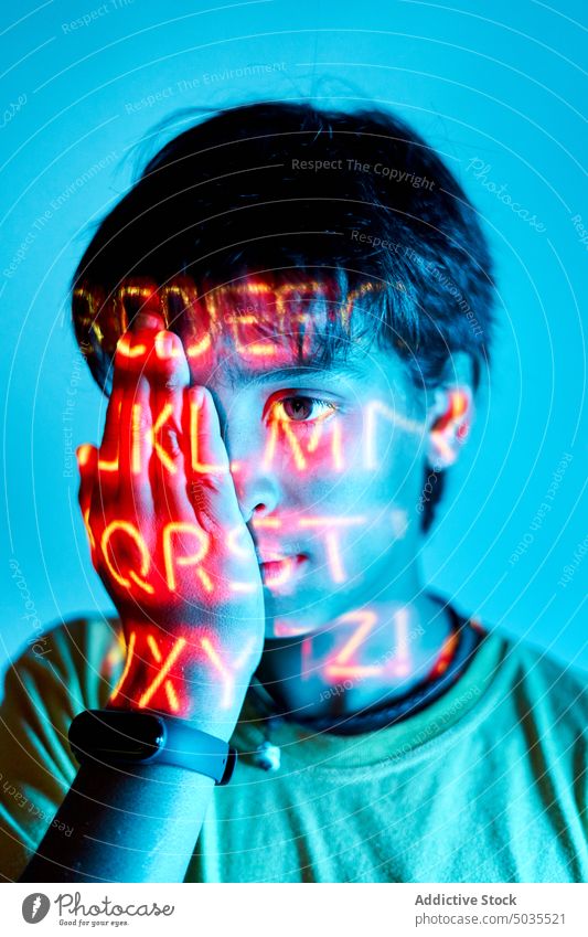Junge im Zimmer mit Neonlicht Porträt Kind neonfarbig Licht leuchten Deckblatt lebhaft hell Raum Kindheit Tierhaut farbenfroh Vorschein Menschliches Gesicht
