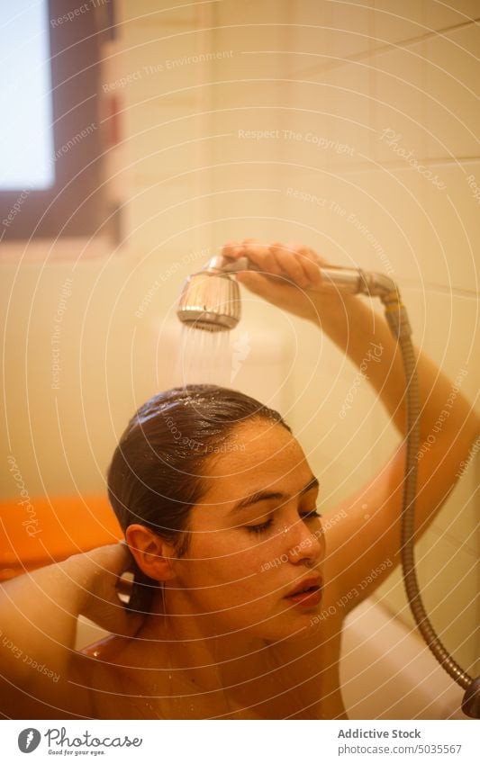 Junge Frau wäscht Haare in der Dusche Duschkopf eingießen Waschen nasses Haar Sauberkeit Wasser Hygiene Bad rein ruhig sinnlich Dame Haare berühren friedlich