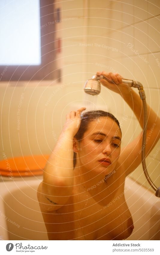 Junge Frau wäscht Haare in der Dusche Duschkopf eingießen Waschen nasses Haar Sauberkeit Wasser Hygiene Bad rein ruhig sinnlich Dame Haare berühren friedlich