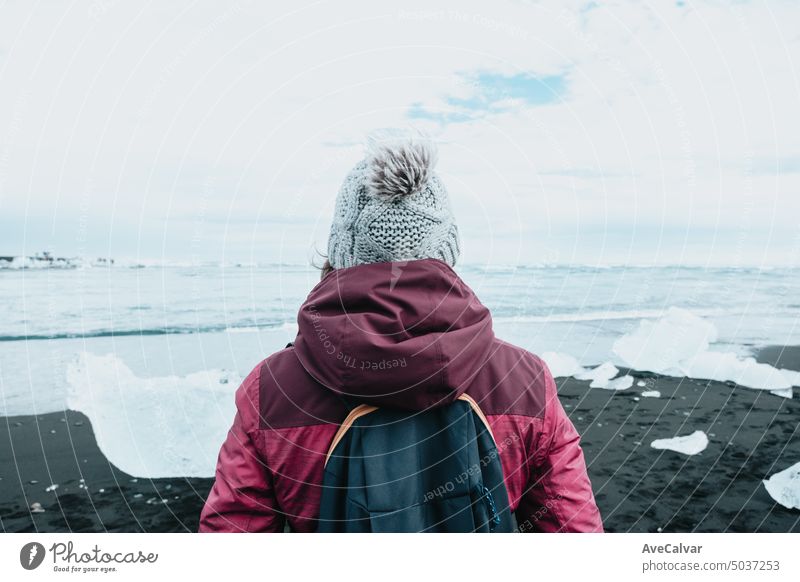 Foto von hinten von einer Frau vor einem Gletscher in Island, Winterreise, kaltes Wetter Konzept. Berge u. Gebirge reisen Reise Fröhlichkeit Menschen wandern
