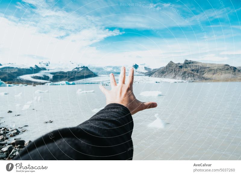 Bild von einer Hand zeigt in Mann vor Gletscher in Island, Winterreise, kaltes Wetter Konzept. Berge u. Gebirge Frau reisen Reise Fröhlichkeit Menschen wandern