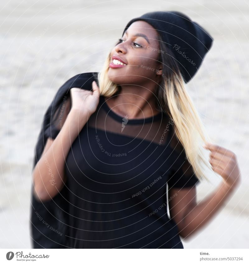 zufrieden lächelnde Frau mit geschulterter Jacke am Strand weiblich Profil genießen wohlfühlen feminin Erholung langhaarig Porträt Oberkörper blond Mütze