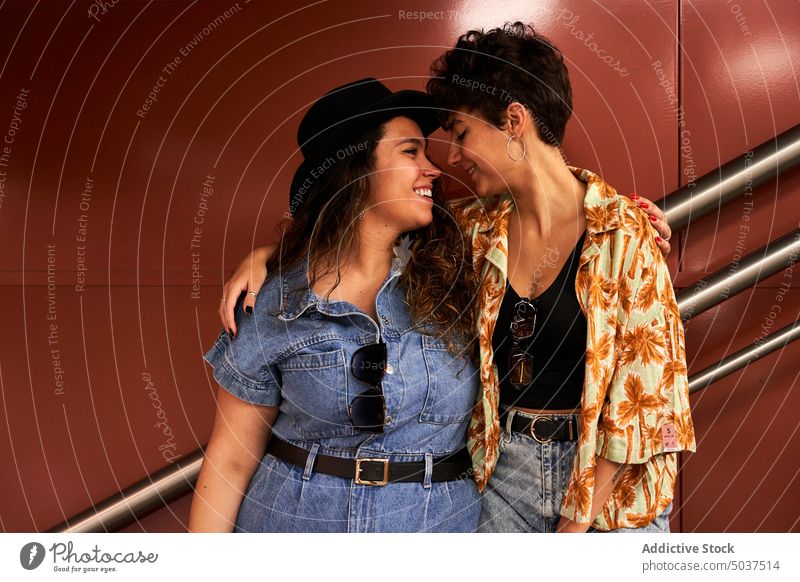 Junge Freundinnen umarmen sich auf der Treppe Frauen Paar Lächeln Umarmung Termin & Datum Liebe Wand Reling Schritt Glück Madrid Spanien Zusammensein Straße