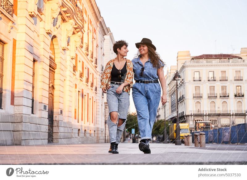 Fröhliche Freundinnen gehen auf der Straße spazieren Frauen Paar Spaziergang Lächeln Wochenende Termin & Datum Glück Madrid Spanien jung Stil Zusammensein