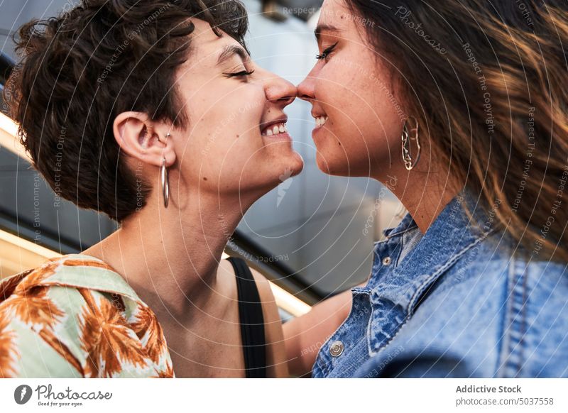 Erfreuliches lesbisches Paar, das sich auf der Treppe umarmt Frauen Berührungsnase Umarmung Lächeln urban Straße unterirdisch Termin & Datum Madrid Spanien jung