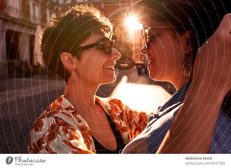 Glückliches Paar umarmt gegen Sonnenuntergang Licht auf der Straße Frauen Lächeln Umarmung Freundin Zusammensein Liebe Madrid Spanien jung Sonnenlicht Dämmerung