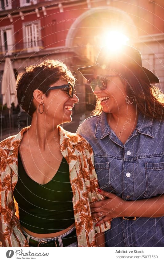 Glückliches Paar umarmt gegen Sonnenuntergang Licht auf der Straße Frauen Lächeln Umarmung Freundin Zusammensein Liebe Plaza Mayor Madrid Spanien jung