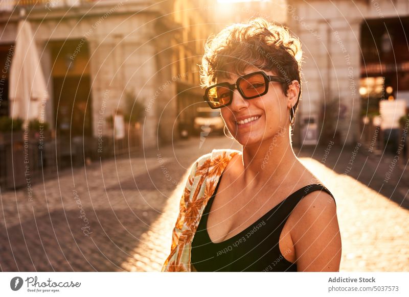 Junge Brünette auf sonnenbeschienener Straße bei Sonnenuntergang Frau Lächeln Stil Glück Sommer Abend Porträt brünett Madrid Spanien jung heiter positiv