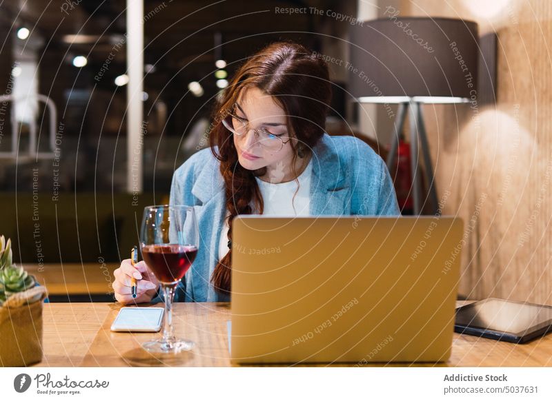 Fokussierte Freiberuflerin, die im Restaurant arbeitet Geschäftsfrau Smartphone benutzend freiberuflich lesen Daten Tisch Abend Telearbeit Frau jung Analyse