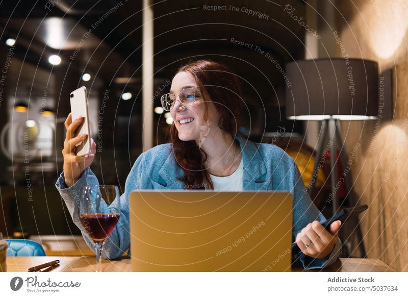 Fokussierte glückliche Freiberuflerin, die im Restaurant arbeitet Geschäftsfrau Smartphone Lächeln benutzend Glück freiberuflich lesen Daten Tisch Abend
