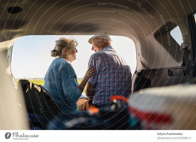 Glückliches älteres Paar im Auto sitzend, offener Kofferraum in der Wildnis Reise Transport Verkehr PKW Straße Autoreise reisen Ausflug Abenteuer Feiertag