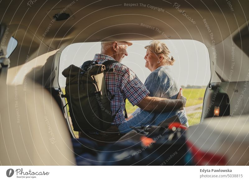 Glückliches älteres Paar im Auto sitzend, offener Kofferraum in der Wildnis Reise Transport Verkehr PKW Straße Autoreise reisen Ausflug Abenteuer Feiertag