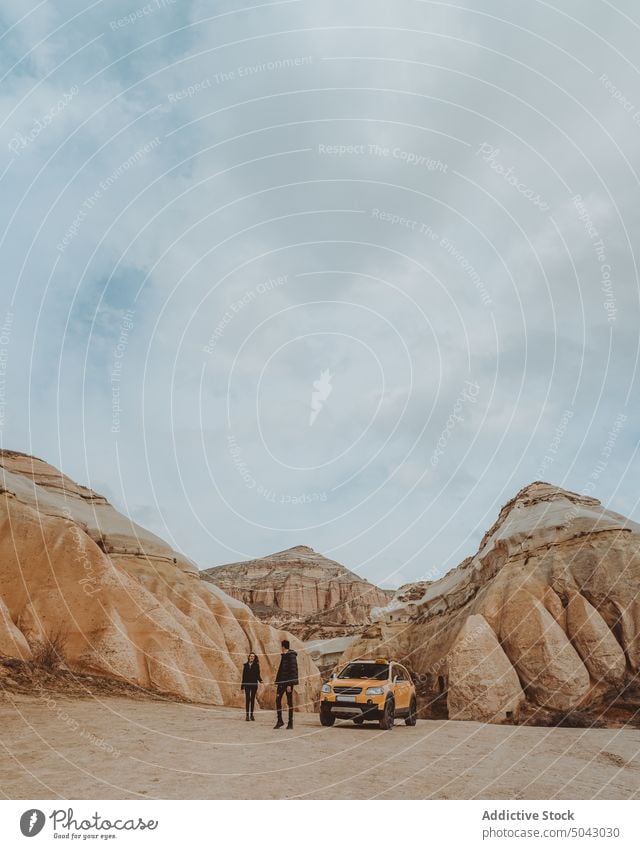 Anonyme Reisende erkunden ein Wüstental mit Felsformationen bei bewölktem Himmel Paar Berge u. Gebirge Spaziergang Fernweh Partnerschaft PKW Ausflug