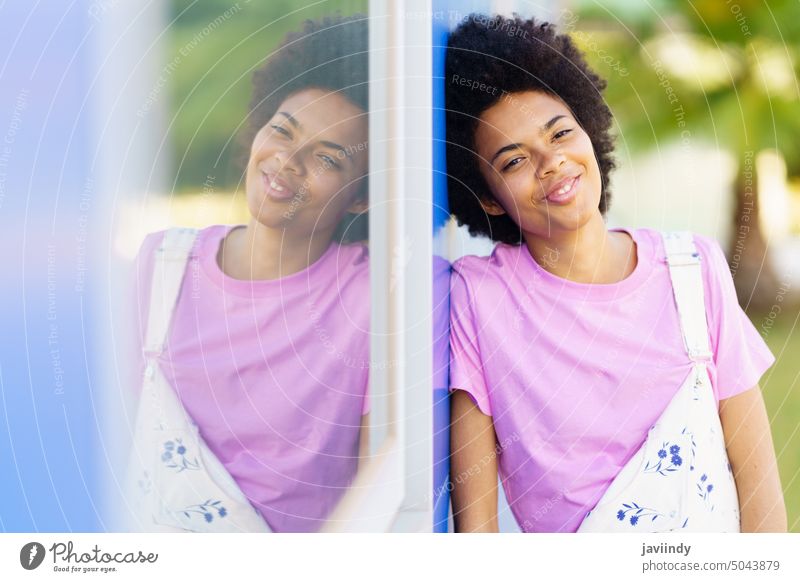 Positive schwarze Frau, die in der Nähe eines Gebäudes steht Straße Großstadt Outfit Stil feminin Fenster Reflexion & Spiegelung Glück Mode gesamt trendy
