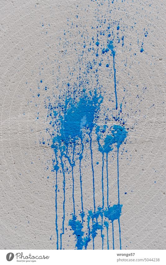 Farbanschlag mit blauer Farbe auf eine graue Fassade Nahaufnahme verlaufend Tag Haus Gebäude Menschenleer Farbfoto Außenaufnahme Wand Sachbeschädigung Hauswand
