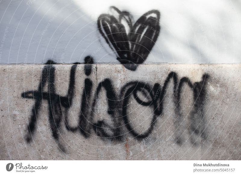 Graffiti mit schwarzer Farbe auf die Wand gemalt. Schwarzes Herz Spray gemalt auf der Steinwand des Gebäudes. Urbane Straßenkunst. künstlerisch Anarchie Symbol