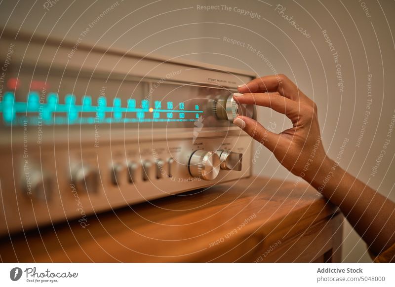 Anonyme Frau beim Einstellen eines Knopfes an einem alten Empfänger Telefonhörer Verstärker Knauf Plattenteller Lautstärke Spieler Aufzeichnen spielen retro