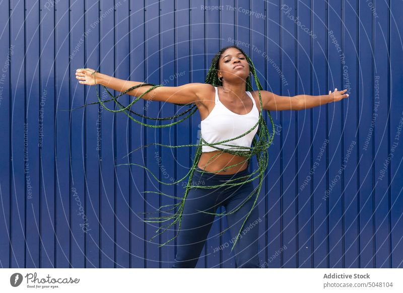 Junge dynamische schwarze Frau tanzt auf der Straße Tanzen cool Freestyle Hip-Hop Stil urban trendy Individualität geflochtenes Haar Bewegung Energie Tänzer