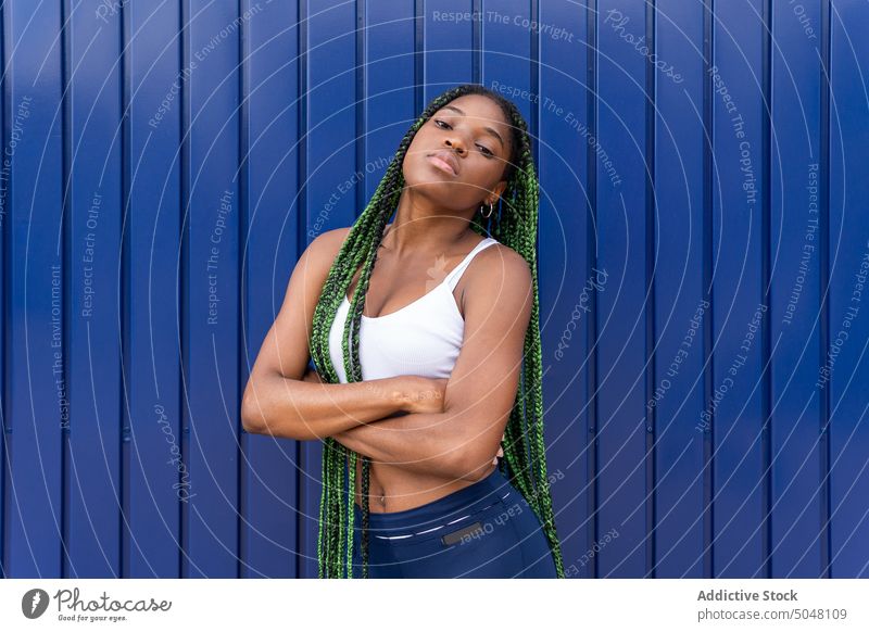 Zeitgenössische junge schwarze Frau mit grünen Zöpfen Individualität selbstsicher Porträt cool Persönlichkeit lange Haare trendy tausendjährig urban