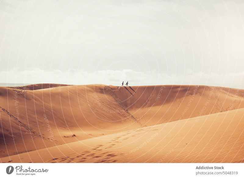 Spaziergänger auf einer Sanddüne Menschen Spaziergang Düne wolkig Himmel Reisender Meeresufer Strand Urlaub Maspalomas Gran Canaria Kanarische Inseln Spanien