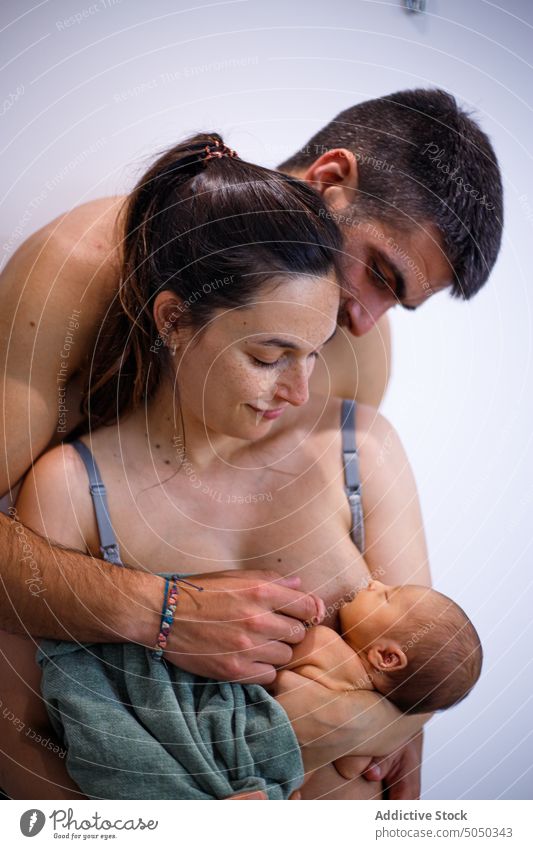 Familie mit neugeborenem Baby umarmen Vater Mutter Säugling Stillen Umarmen Angebot sanft Umarmung Zusammensein Pflege Eltern Liebe Zuneigung Kind Partnerschaft