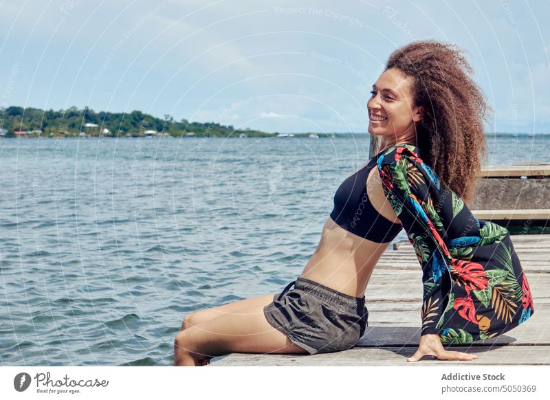 Entspannt lächelnde Frau baumelt Beine im Wasser von Pier Sommer Glück heiter tropisch ruhen sorgenfrei sich[Akk] entspannen schäbig friedlich Gelassenheit MEER