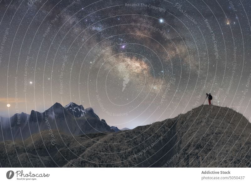 Reisender Fotograf auf dem Gipfel eines Berges im Winter stehend Milchstrasse Mann Fotografie Stern Nacht Island Vestrahorn Fotoapparat Berge u. Gebirge Stativ