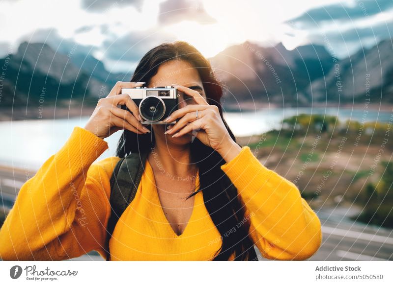 Frau, die ein Foto mit der Kamera macht, während sie in der Natur unterwegs ist Reisender Tourist Fotoapparat fotografieren schießen Fotograf Urlaub Ausflug