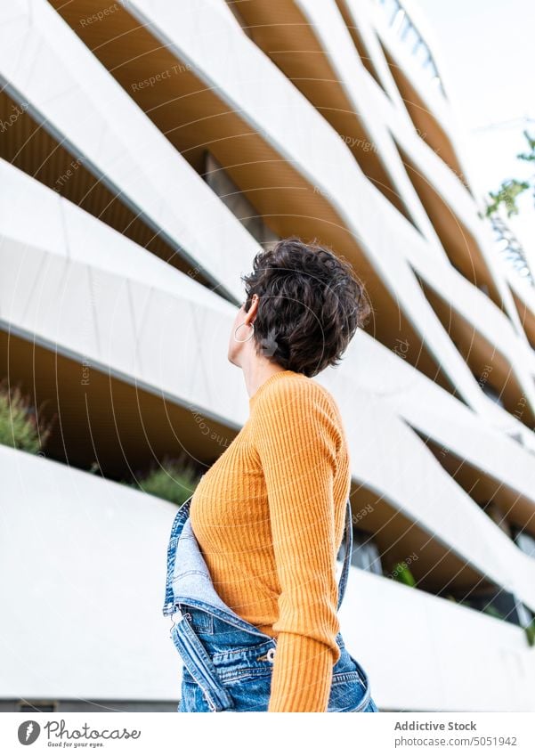 Anonyme Frau mit Blick auf ein städtisches Gebäude Großstadt bewundern urban Architektur Stil Straße Jeansstoff Konstruktion Kurze Haare Frisur kreativ