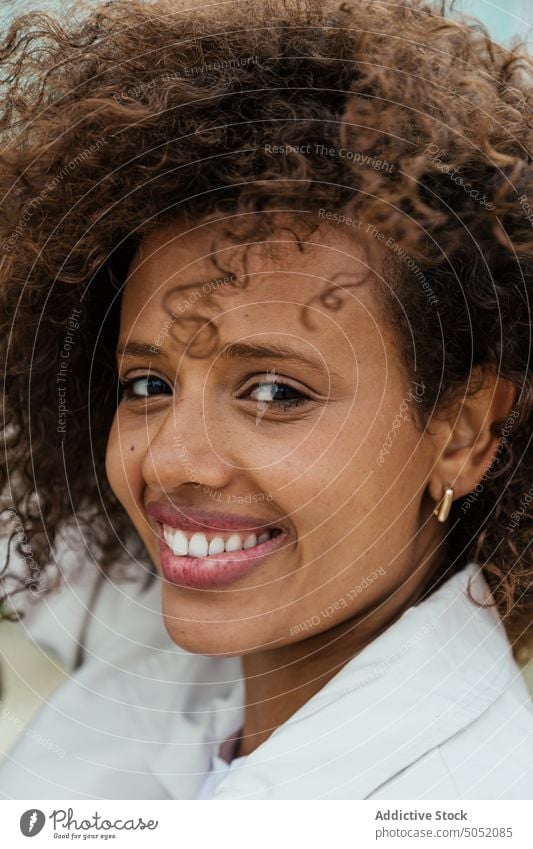 Fröhliche schwarze Frau schaut in die Kamera Lächeln Glück herzlich Stil Vorschein Porträt krause Haare natürlich charismatisch ethnisch Afroamerikaner jung