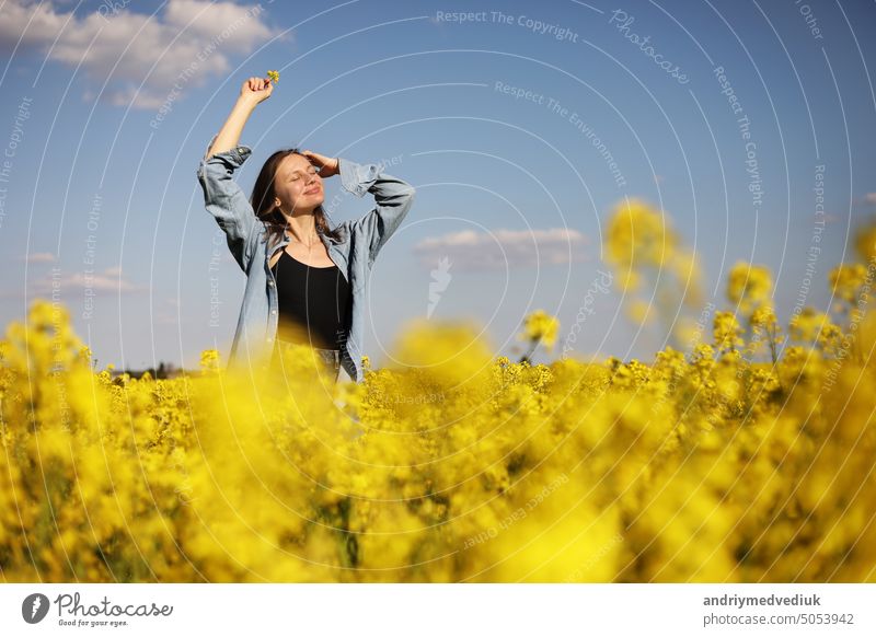 Junge schöne Frau in einem Feld mit gelb blühendem Raps. Mädchen in gelbem Blumenfeld, Rapsplantage, Sommerurlaub Konzept jung Schönheit Natur Glück