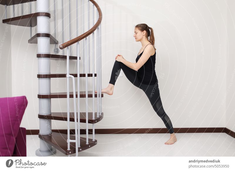 Macht Übungen. Junge Frau mit schlanken Körperform in Sportkleidung haben Fitness-Tag drinnen zu Hause. jung im Innenbereich Yoga heimwärts Sportbekleidung Form